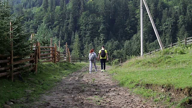 一对背包客在山路上徒步旅行视频素材