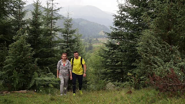 一对背包客在山路上徒步旅行视频素材