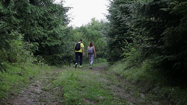 一对背包客在山路上徒步旅行视频素材