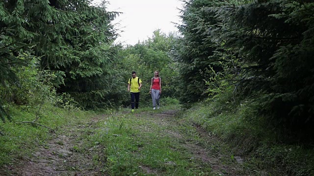 一对背包客在山路上徒步旅行视频素材