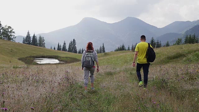 一对背包客在山路上徒步旅行视频素材