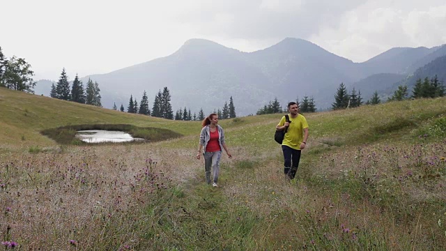 一对背包客在山路上徒步旅行视频素材