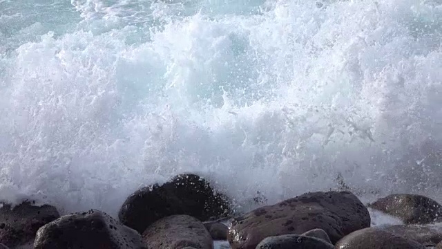 慢镜头特写:海浪破碎并溅入火山岩视频素材