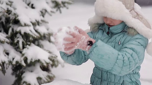 女孩冬天在雪地里堆雪人。视频素材