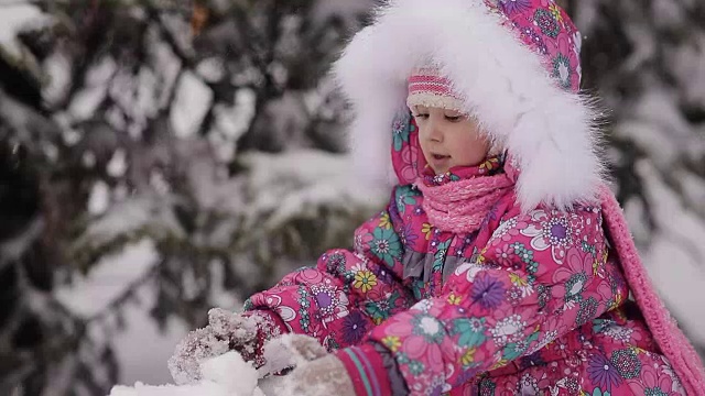 女孩冬天在雪地里堆雪人。视频素材