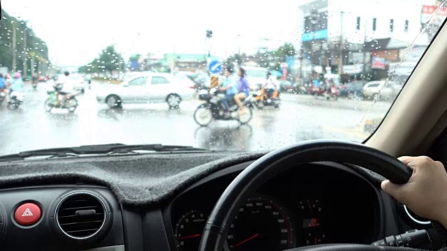 在雨天开车穿过城市的女人的车里看视频素材