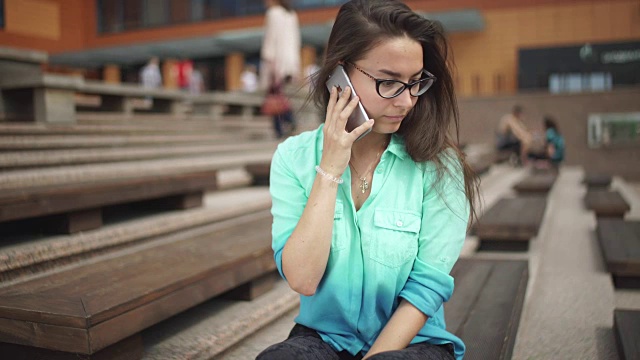 年轻漂亮的女人在用手机。手机在手里视频素材