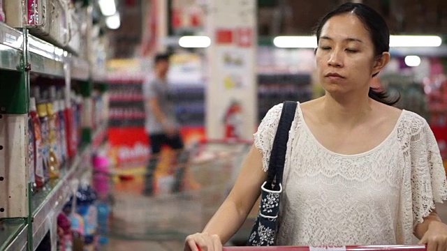 亚洲女孩，女人走，看和购物的超市岛视频素材