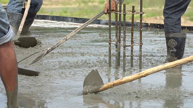 建筑工人从水泥搅拌机中倒入混凝土混合物视频素材