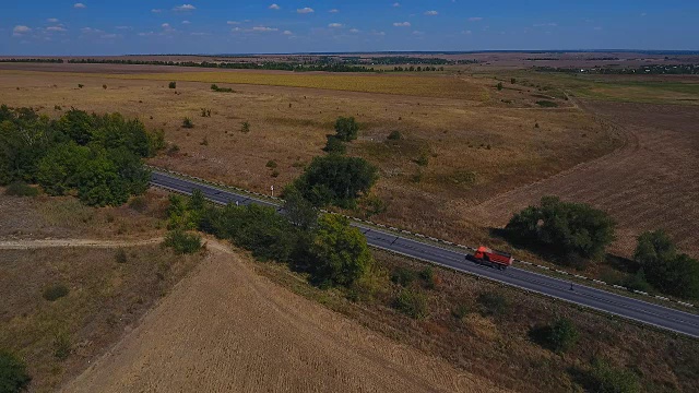 鸟瞰图的村庄道路和收获的田地。视频素材