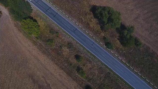 鸟瞰图的村庄道路和收获的田地。视频素材