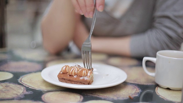 一个女孩正在用叉子切一块蛋糕视频素材