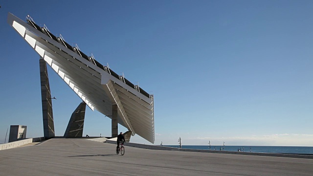 大型太阳能电池板建筑和ciclist运行视频下载