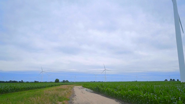 风力发电机。从风力涡轮机到乡村公路绿地视频素材