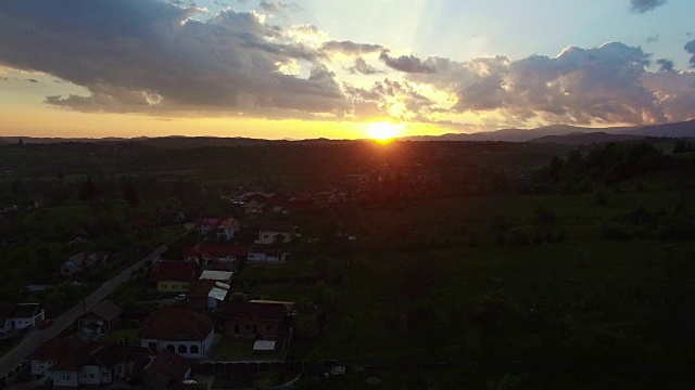 飞过绿色的山丘和村庄，美丽的夕阳视频素材