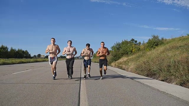 一群在高速公路上慢跑的人。夏季男性运动运动员在户外训练。年轻强壮的男人锻炼在农村道路上一起锻炼。积极的生活方式。慢动作视频素材