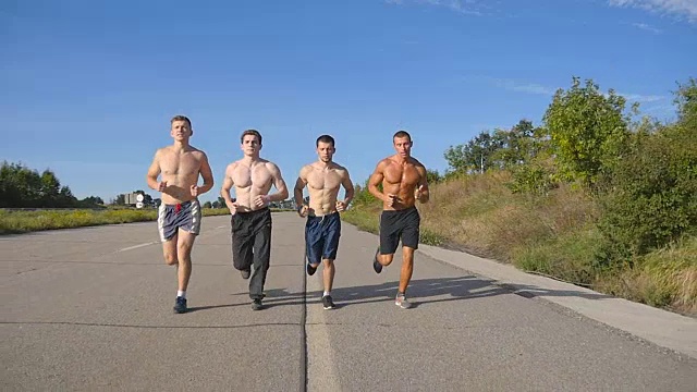 一群在高速公路上慢跑的人。夏季男性运动运动员在户外训练。年轻强壮的男人锻炼在农村道路上一起锻炼。积极的生活方式。慢动作视频素材