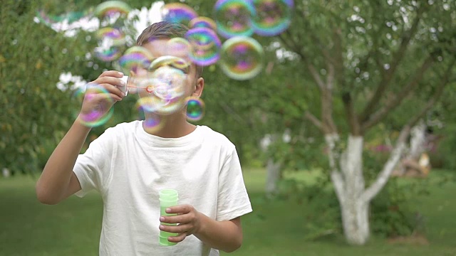 那男孩在花园里吹泡泡视频素材