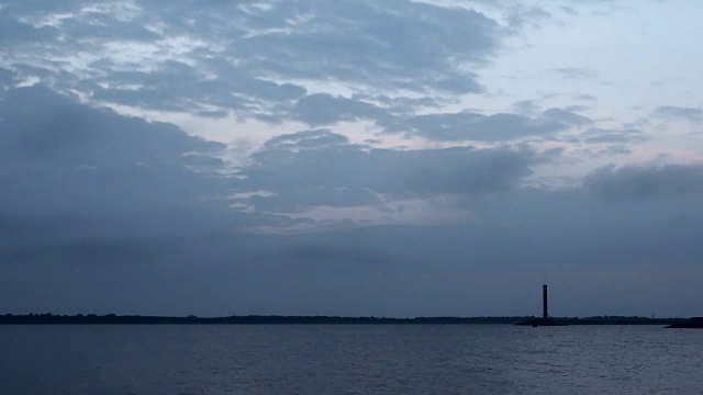 黎明的时间流逝，海面上有灯塔和云彩视频素材