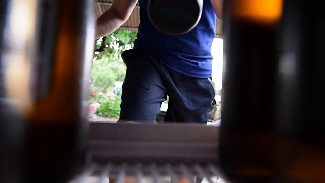 亚洲人把啤酒放在冰箱里视频素材