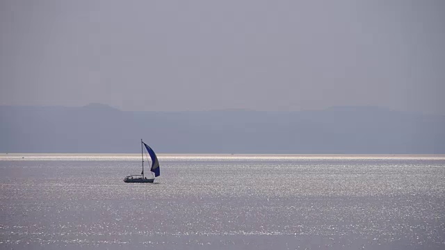 风平浪静，小帆船在滑翔。日落视频素材