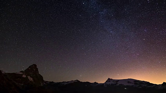 在雄伟的马特洪峰或维诺峰和蒙特罗莎冰川之上的星空明显旋转，意大利一侧。时间流逝的视频。视频素材