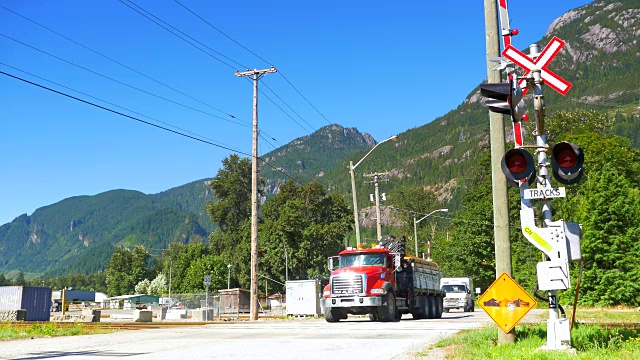 重型卡车通过火车轨道障碍跨越标志和障碍视频素材