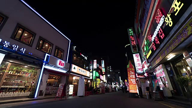 在韩国首尔，人们和汽车在夜晚灯光照亮的街道上的时间流逝视频素材