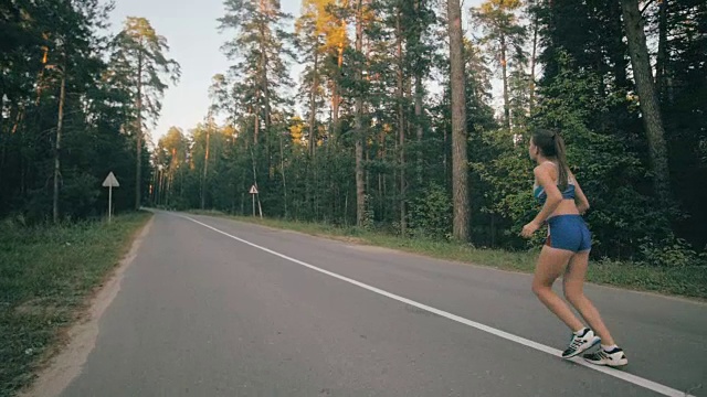 健身锻炼。年轻女人跑。女跑步者在公园的路上慢跑。健身锻炼。Slowmotion视频素材