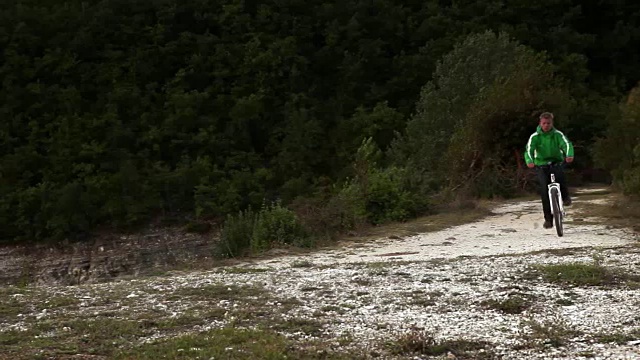 秋天，一名骑山地车的男子在湖边骑山地车下山视频素材