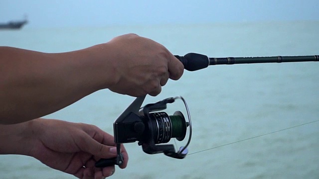 男性在夏季户外活动中纺丝钓鱼竿视频素材