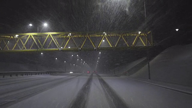 晚上在雪地里在高速公路上开车视频素材