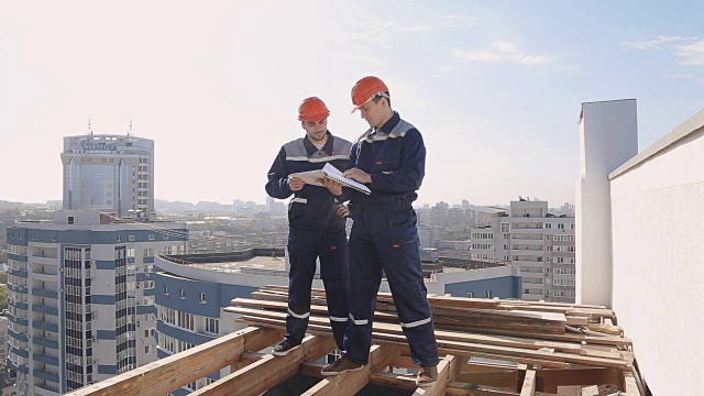 两个建筑工地的工人拿着设计图视频下载