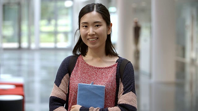 一名亚裔女大学生走进大厅视频素材