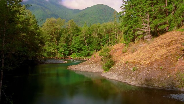 时光流逝河与森林覆盖的山脉和云的背景/奥林匹克半岛，华盛顿视频素材