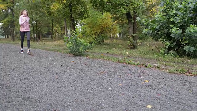 女人跑公园年轻的活跃的健身女跑步者锻炼户外运动女孩慢跑早晨秋天森林视频素材