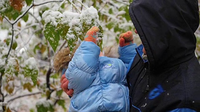 男孩和孩子在玩一根白雪覆盖的树枝视频素材