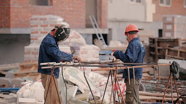 两个建筑工将管子焊接到建筑物上视频素材