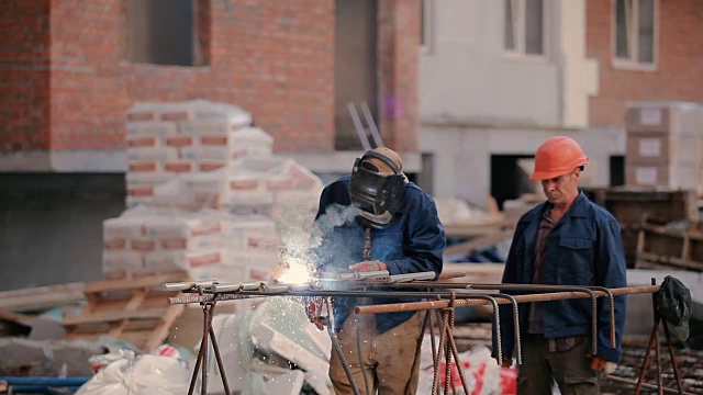 那个人把管子焊接到建筑物上视频素材