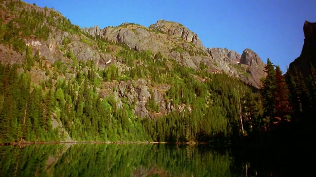 低角度pan岩石山与松树和湖在前景/奥林匹克山，奥林匹克半岛，华盛顿视频素材