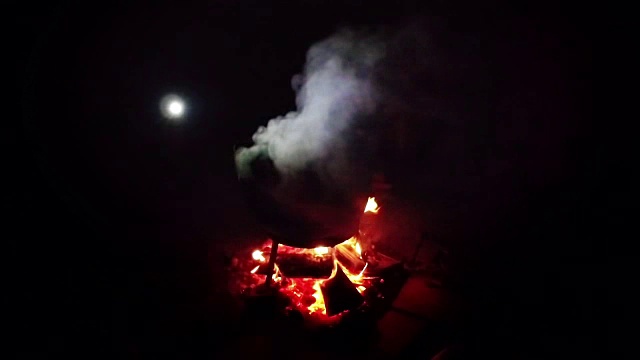 营食品游客。火上的锅里的食物，背景中的月亮视频素材