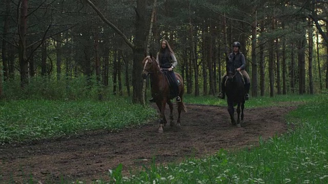 两个小女孩在森林里骑马视频素材