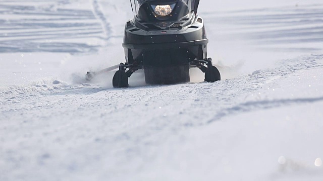 雪地摩托在阳光下加速行驶视频素材