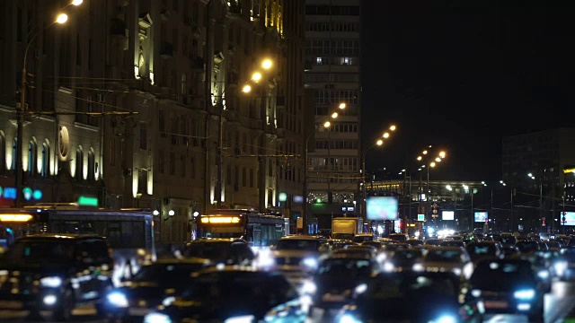 夜间城市的交通堵塞。路边的广告牌模糊不清。视频素材