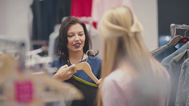 女人花时间在商店里。两个女朋友试穿衣服视频素材