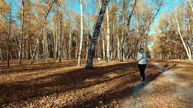 女孩在清晨的森林里奔跑。体育运动视频素材