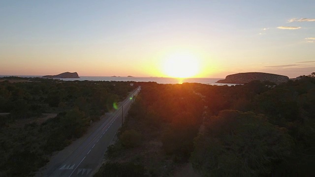 无人机拍摄到一条穿过树木通往海岸的道路视频素材