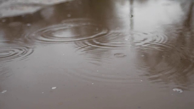 水坑里的雨点溅起蓝色的秋色，阴沉沉的视频素材