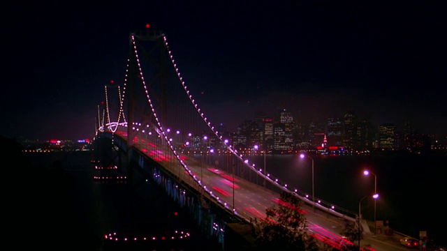 宽镜头时间推移在海湾大桥上的交通在夜晚/城市景观背景/旧金山，加利福尼亚视频素材