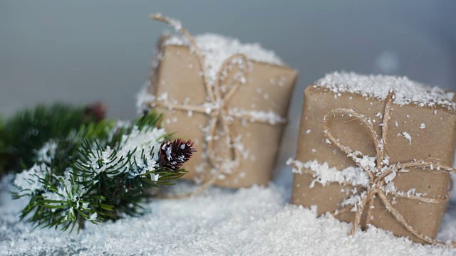 用来装礼物的圣诞盒子和树枝在雪地里的白色背景上视频素材